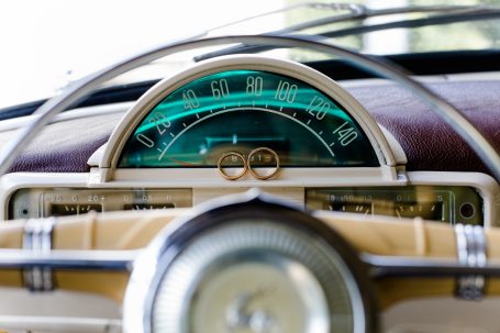 Fahrtinstrumente eines klassischen Autos mit einem eleganten Lenkrad und Ringen.