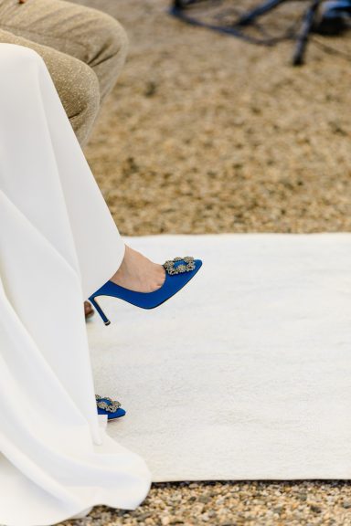 Füße in eleganten blauen Schuhen auf einem weißen Teppich.