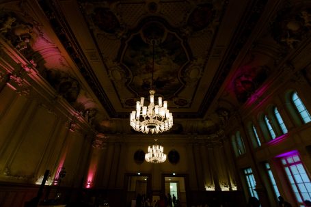 Prächtiger Raum mit Kristalllüster und bunten Lichtern an den Wänden.