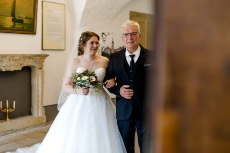 Braut in einem weißen Kleid mit ihrem Vater beim Einzug in der Zeremonie.