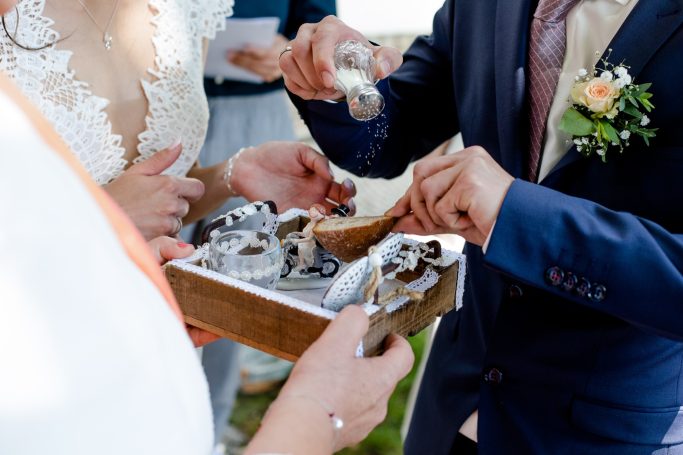 Hochzeitsringtausch mit einer Schachtel voller Ringe und festlicher Kleidung.