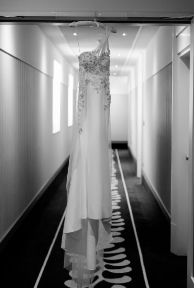Hängendes Brautkleid in einem flurartigen Raum mit hellem Hintergrund.