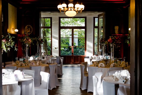 Eleganter Speisesaal mit gedeckten Tischen und großen Fenstern für Tageslicht.