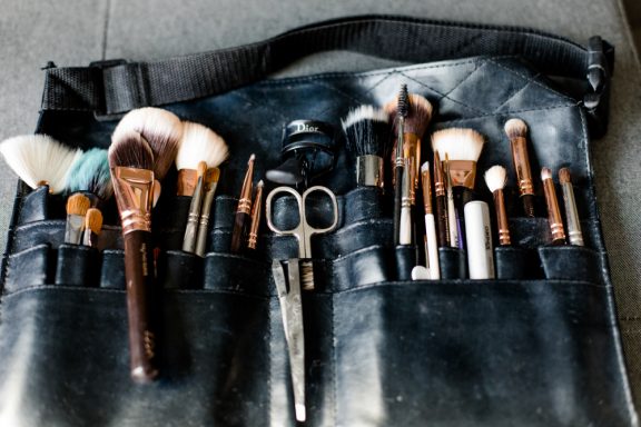 Make-up Pinsel und Werkzeuge in einer dunkelgrauen Tasche angeordnet.